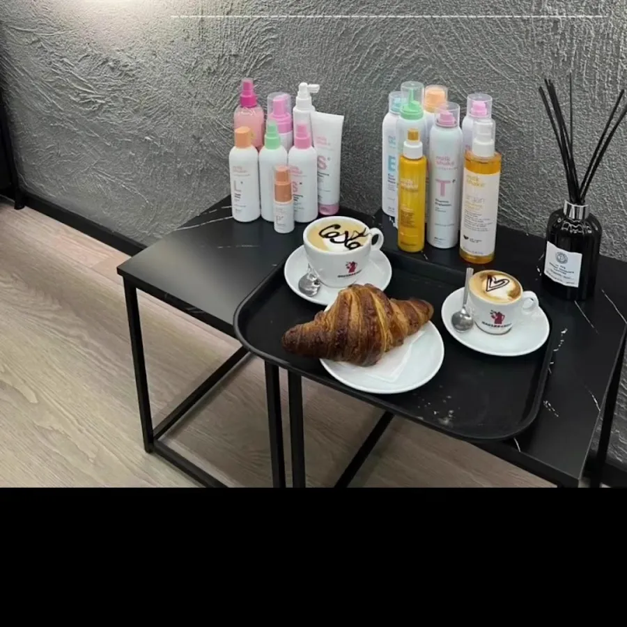 Cappuccino e cornetto serviti ai clienti, accanto ai prodotti del salone